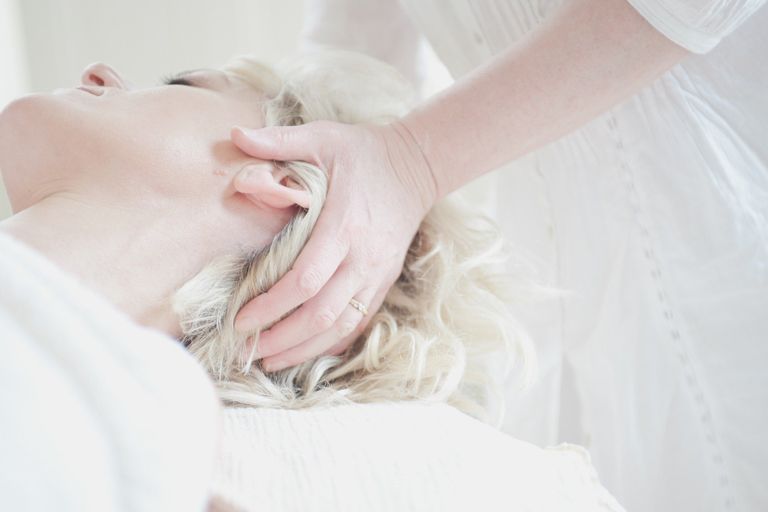 Klientin bekommt eine entspannende biodynamische Massage am Kopf
